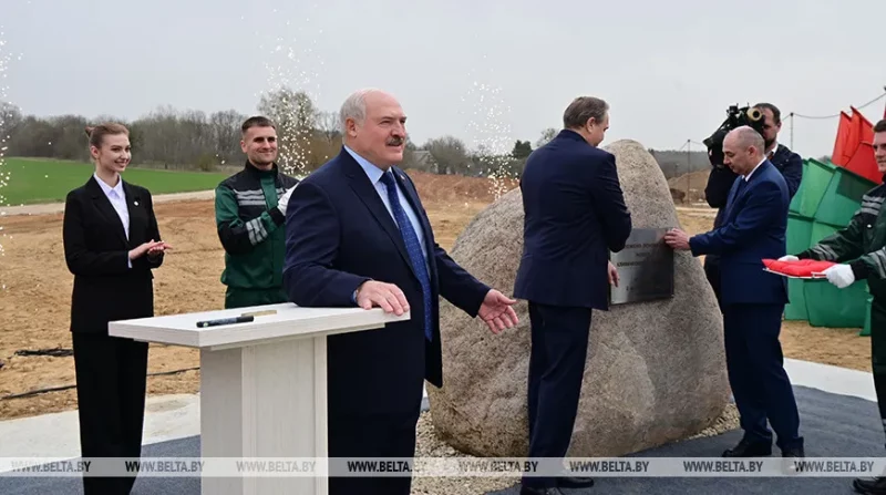Лукашенко на стройплощадке в поле на Янки Купалы рассказывает о заработках врачей. Справа — камень, куды заложили «капсулу времени»